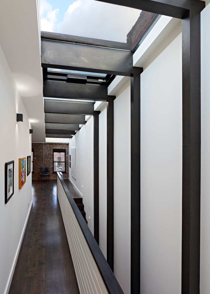 Immagine di un ingresso o corridoio minimalista di medie dimensioni con pareti bianche, parquet scuro, pareti in legno e pavimento marrone