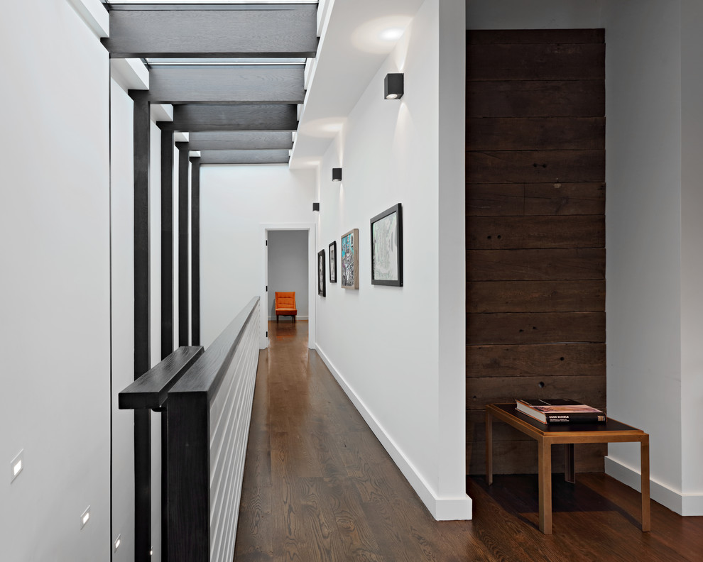 Mittelgroßer Moderner Flur mit weißer Wandfarbe, dunklem Holzboden, Holzwänden und braunem Boden in New York