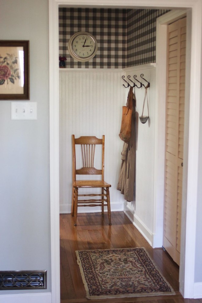 Example of a small cottage medium tone wood floor hallway design in Other