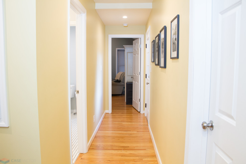 Mittelgroßer Klassischer Flur mit gelber Wandfarbe, hellem Holzboden und orangem Boden in Charleston