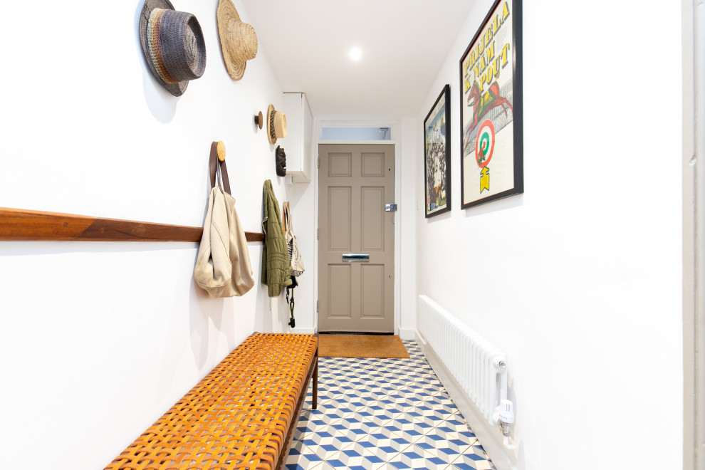 Ejemplo de recibidores y pasillos minimalistas de tamaño medio con paredes blancas, suelo de baldosas de cerámica, suelo multicolor y bandeja