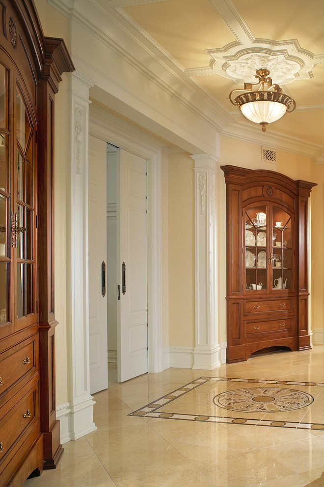 Immagine di un grande ingresso o corridoio classico con pareti beige e pavimento in marmo
