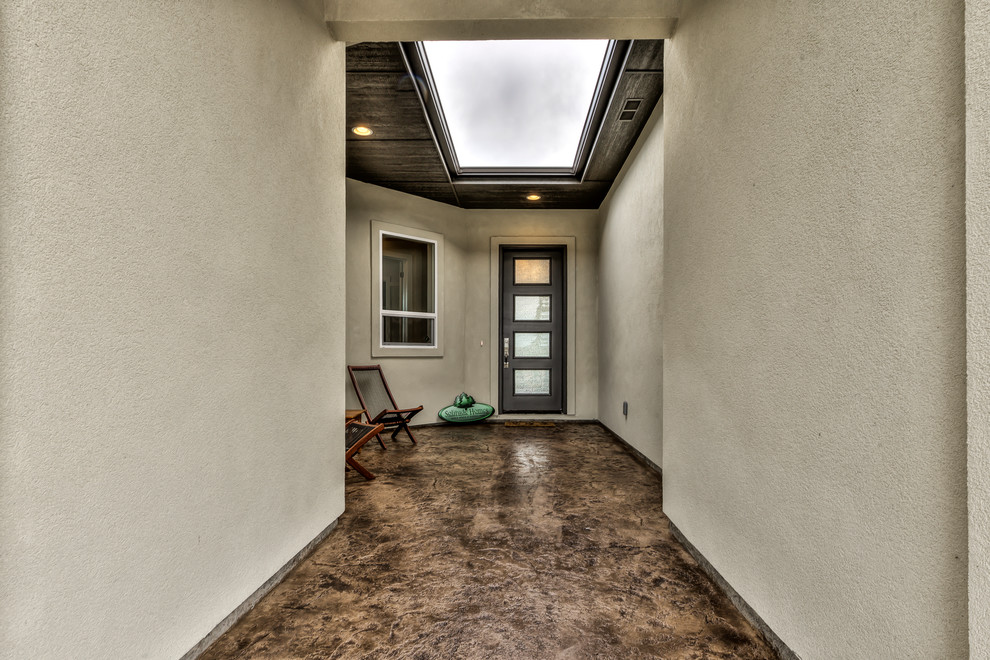Ejemplo de recibidores y pasillos minimalistas grandes con paredes beige, suelo de cemento y suelo marrón