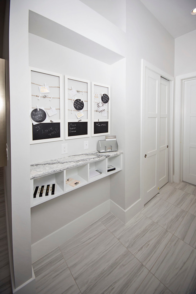 Cette image montre un grand couloir minimaliste avec un mur blanc, un sol en marbre et un sol gris.