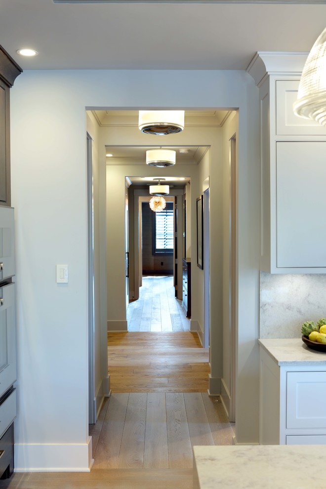 Mid-sized minimalist light wood floor and brown floor hallway photo with white walls