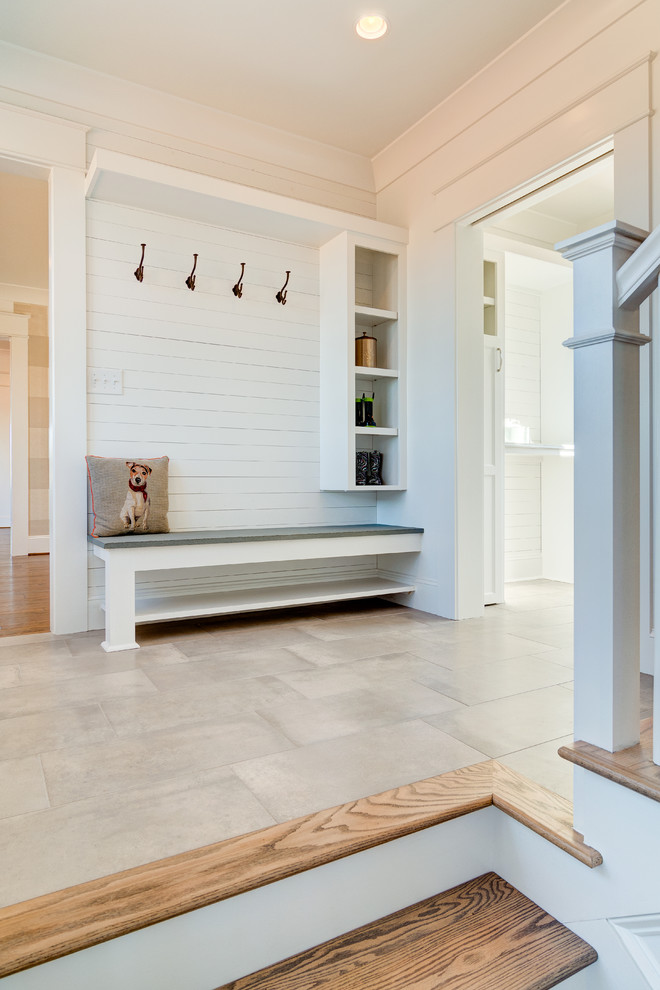 Example of a mid-sized farmhouse ceramic tile and gray floor hallway design in Other with white walls