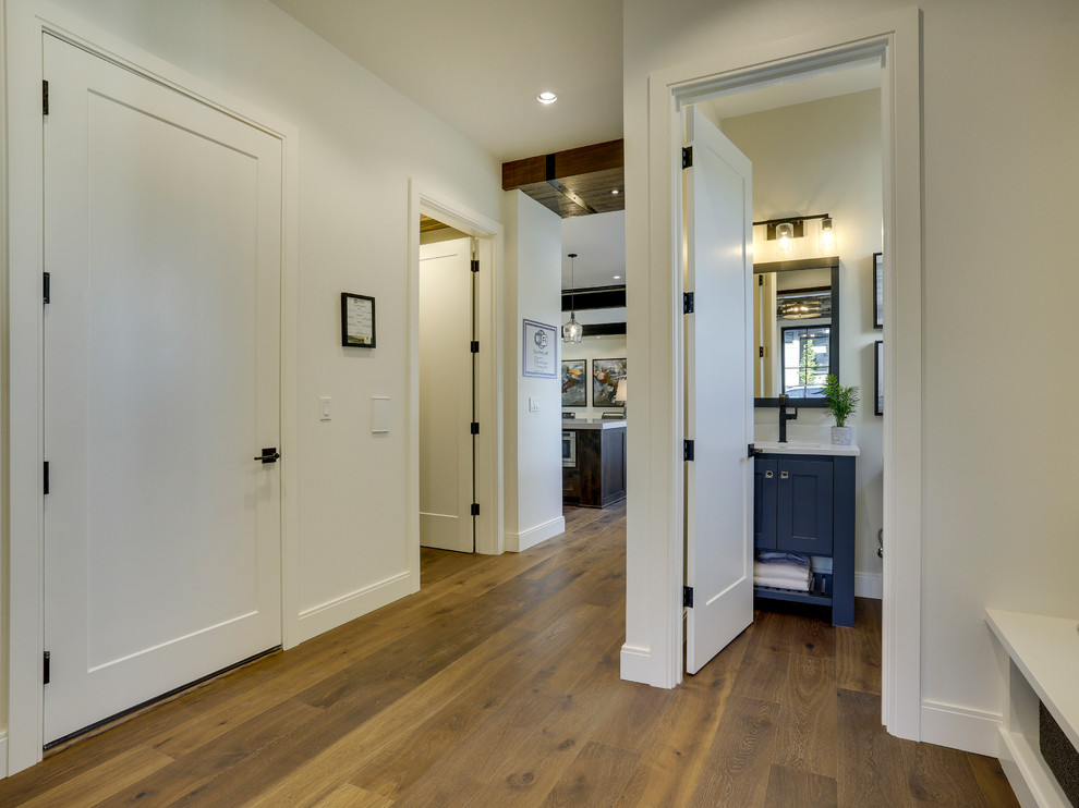 Inspiration for a mid-sized farmhouse medium tone wood floor and brown floor hallway remodel in Portland with white walls