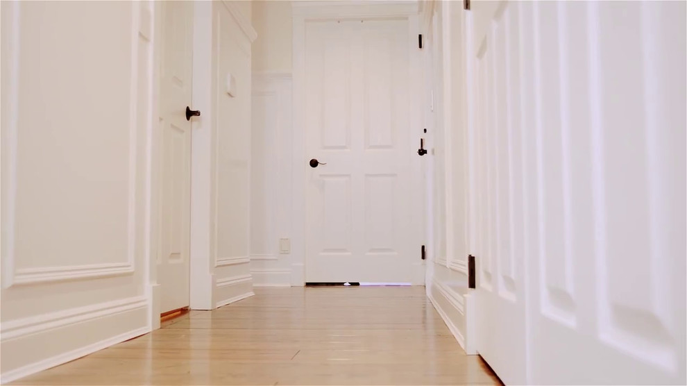 Idee per un grande ingresso o corridoio classico con pareti bianche, pavimento in legno massello medio e pavimento marrone