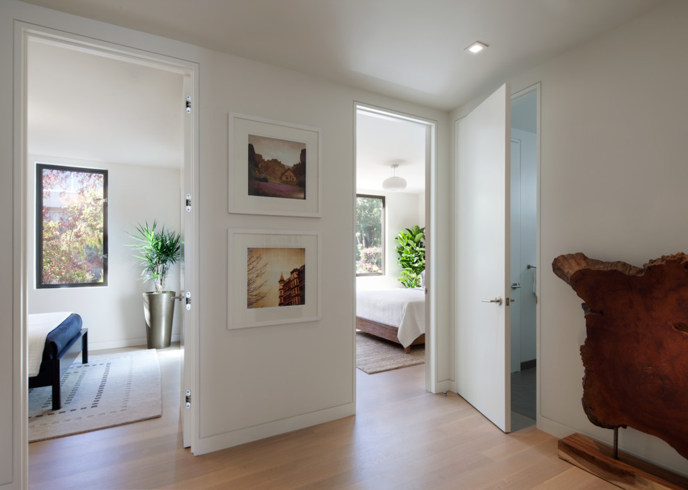 Esempio di un ingresso o corridoio minimal di medie dimensioni con pareti bianche e parquet chiaro