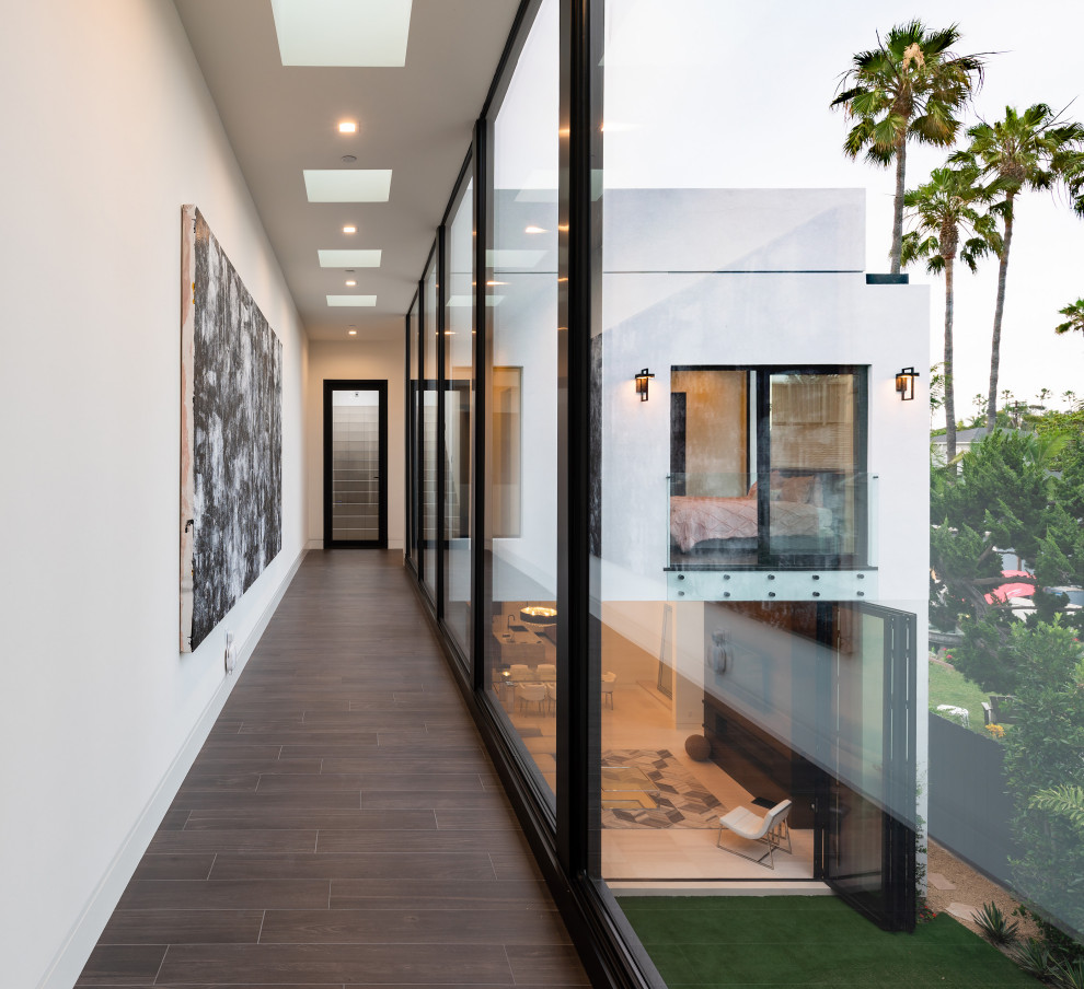 Hallway - mid-sized contemporary brown floor hallway idea in San Diego with white walls