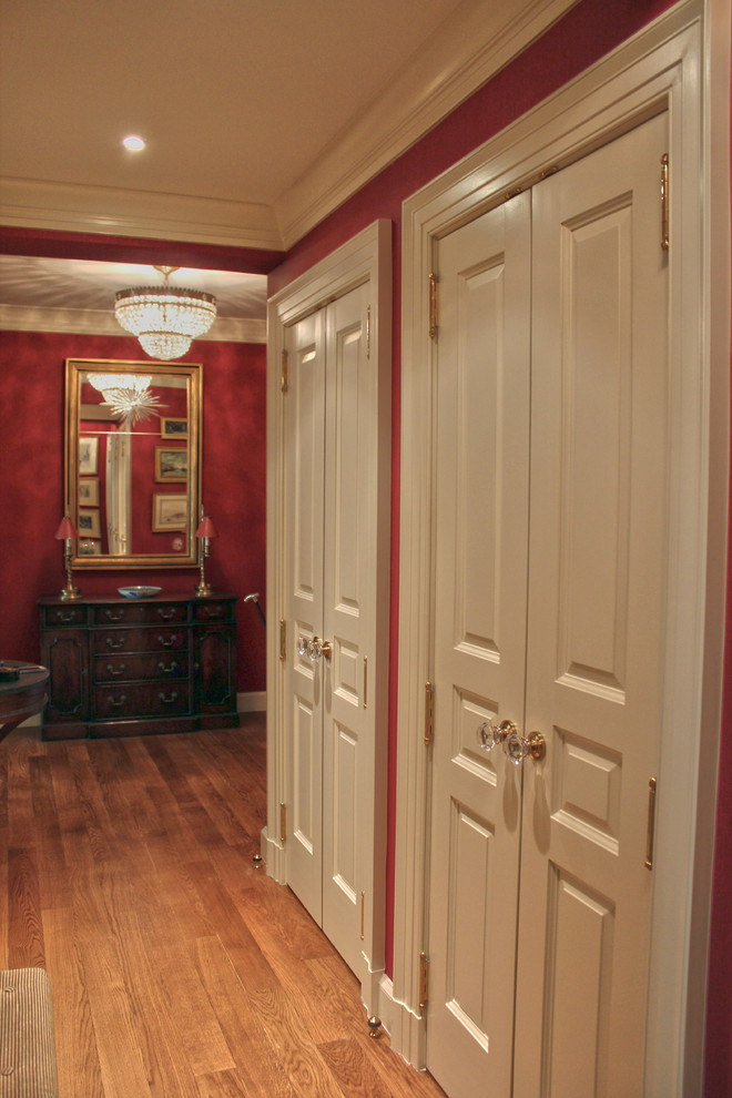 Hallway - small traditional medium tone wood floor hallway idea in New York with red walls