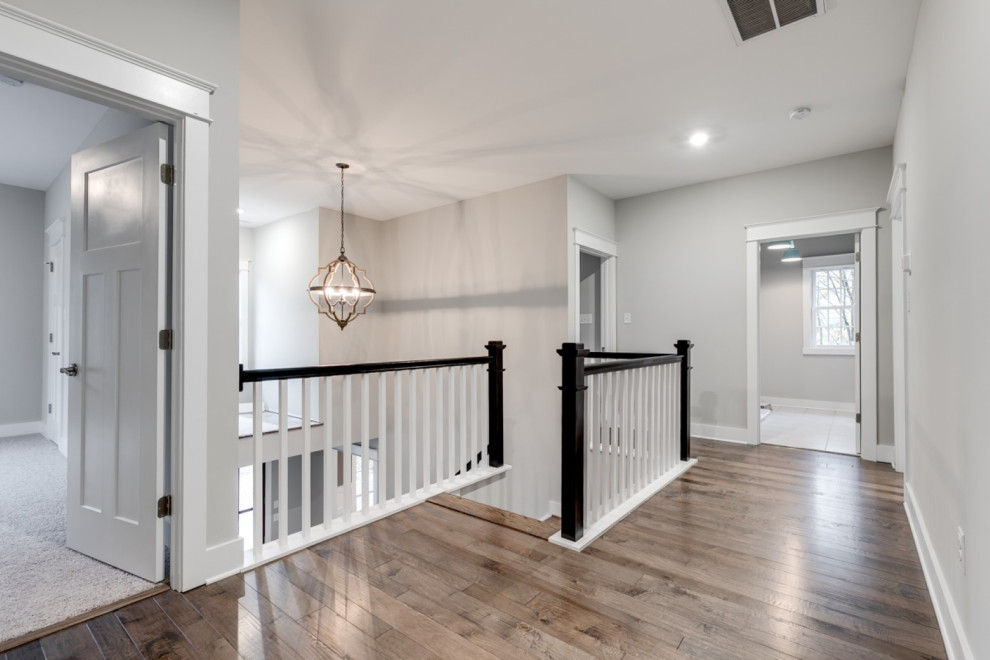 Hallway - large craftsman medium tone wood floor and gray floor hallway idea in Richmond with gray walls
