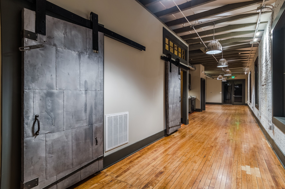 Inspiration for a large industrial light wood floor hallway remodel in Baltimore with gray walls