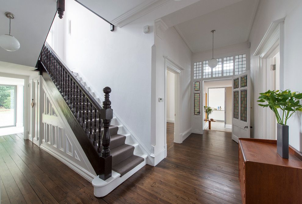 Стильный дизайн: коридор в викторианском стиле с белыми стенами, паркетным полом среднего тона и коричневым полом - последний тренд