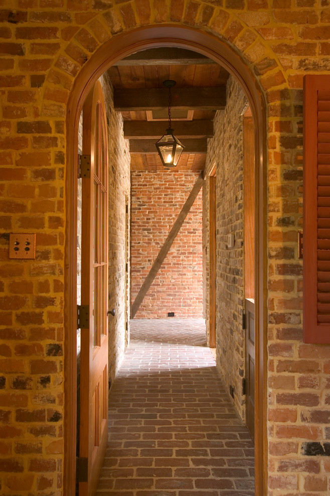 Cette photo montre un couloir chic avec un sol en brique.