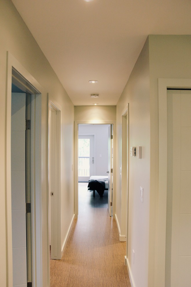 Cette photo montre un couloir moderne de taille moyenne avec un mur gris et un sol en liège.