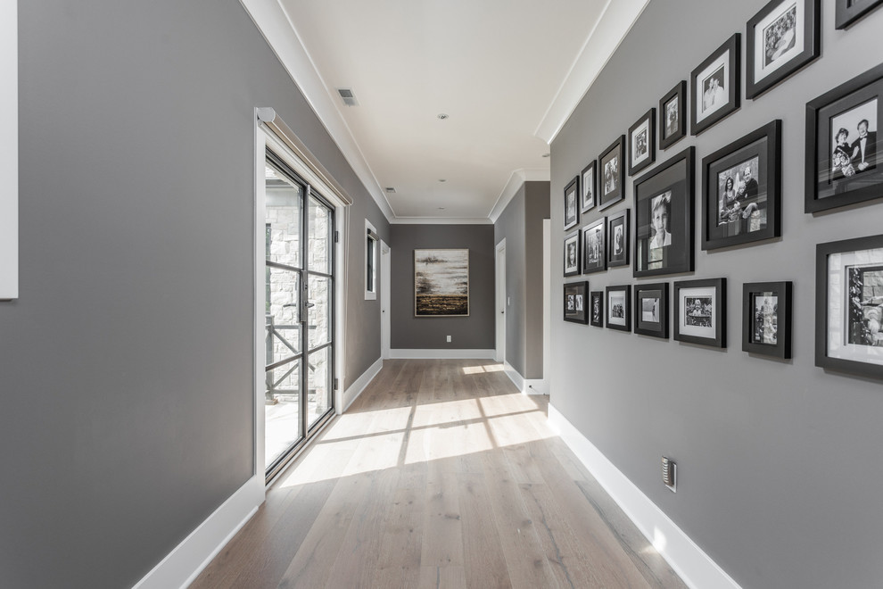 Idées déco pour un grand couloir méditerranéen avec un mur gris et un sol en bois brun.