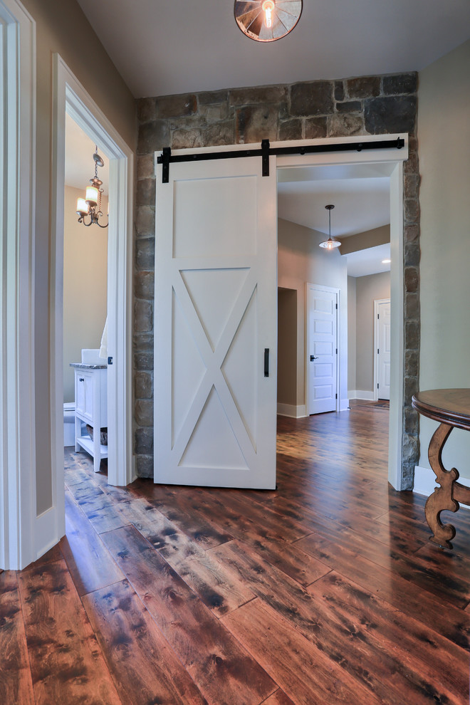 Example of a large cottage medium tone wood floor hallway design in Other with beige walls