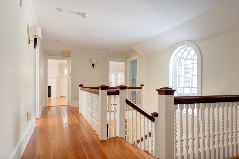 Huge elegant medium tone wood floor hallway photo in Boston with beige walls