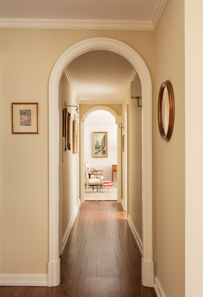 Idee per un ingresso o corridoio chic di medie dimensioni con pareti beige, pavimento in legno massello medio e pavimento marrone