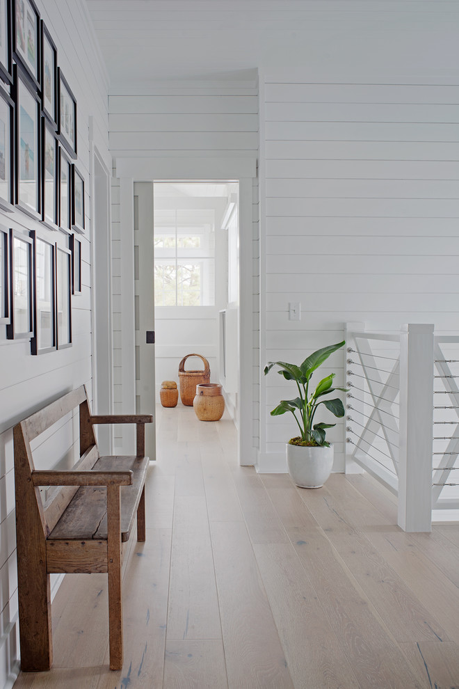 Пример оригинального дизайна: маленький коридор в морском стиле с белыми стенами, светлым паркетным полом и коричневым полом для на участке и в саду