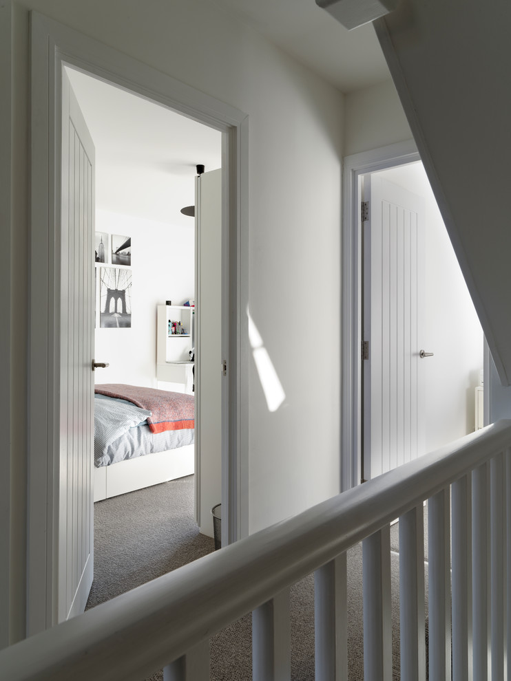 Immagine di un piccolo ingresso o corridoio minimal con pareti bianche, moquette e pavimento grigio