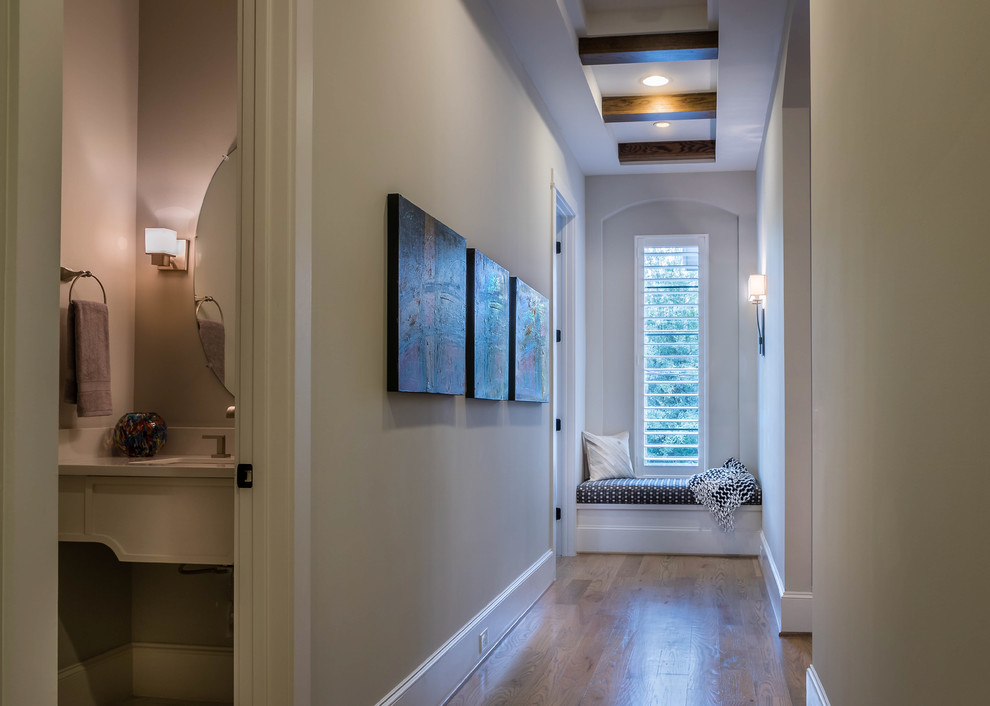 Example of a mid-sized transitional medium tone wood floor and brown floor hallway design in Houston with gray walls
