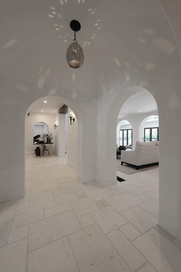 Imagen de recibidores y pasillos mediterráneos de tamaño medio con paredes blancas, suelo de piedra caliza y suelo blanco