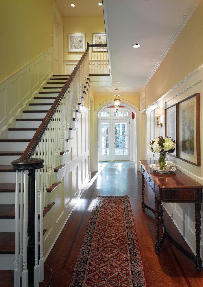 Источник вдохновения для домашнего уюта: большой коридор в классическом стиле с желтыми стенами, темным паркетным полом и коричневым полом