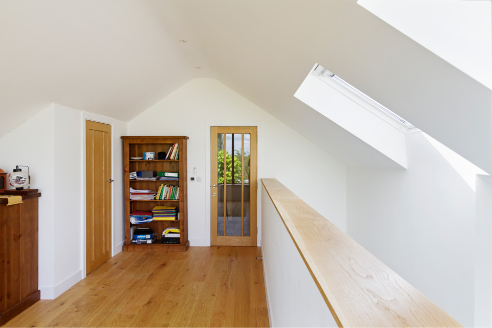 Ejemplo de recibidores y pasillos abovedados minimalistas de tamaño medio con paredes blancas, suelo laminado y suelo beige