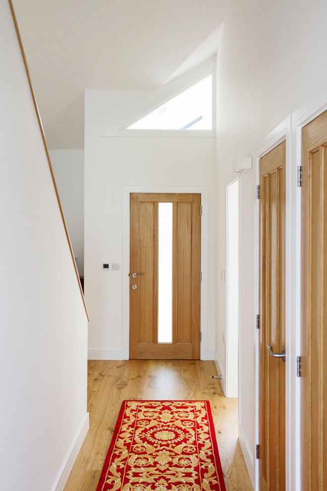 Источник вдохновения для домашнего уюта: коридор среднего размера в стиле модернизм с белыми стенами, полом из ламината, бежевым полом и сводчатым потолком