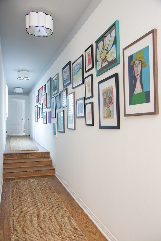 Inspiration for a mid-sized eclectic light wood floor and brown floor hallway remodel in Los Angeles with white walls