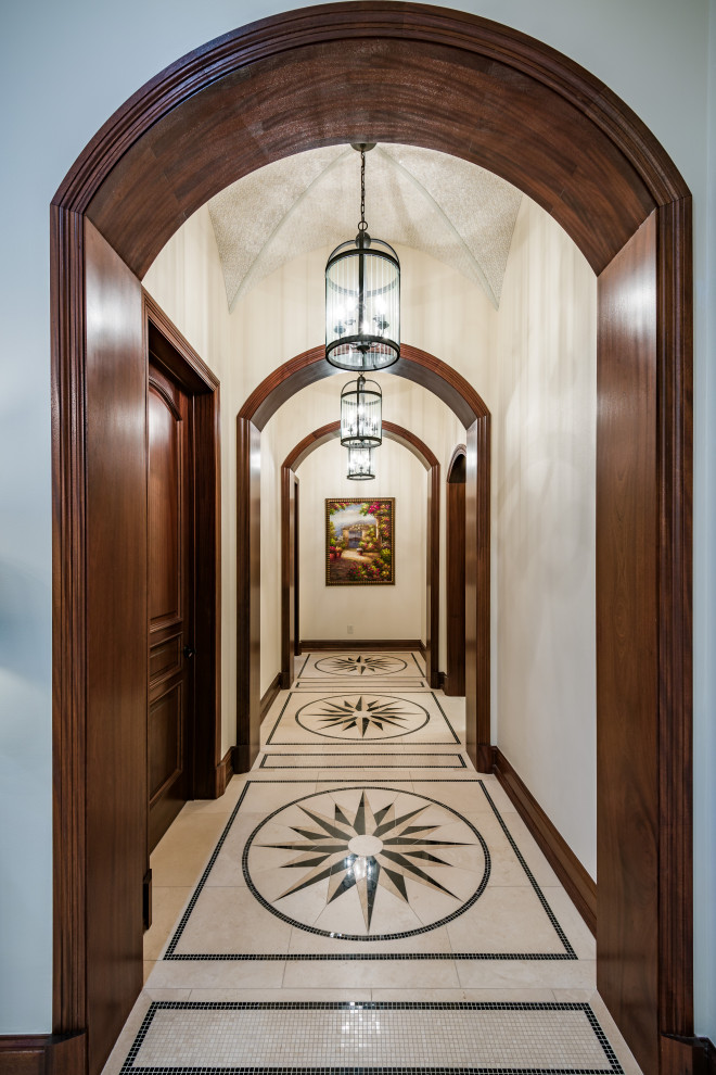 ダラスにある広いトラディショナルスタイルのおしゃれな廊下 (白い壁、トラバーチンの床、ベージュの床) の写真