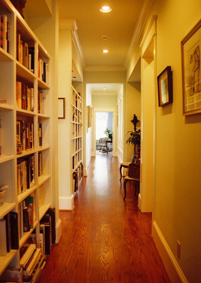 Cette photo montre un couloir chic avec un mur beige et un sol en bois brun.