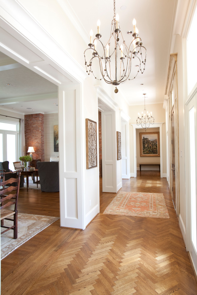 Hallway - large traditional medium tone wood floor hallway idea in Houston with white walls