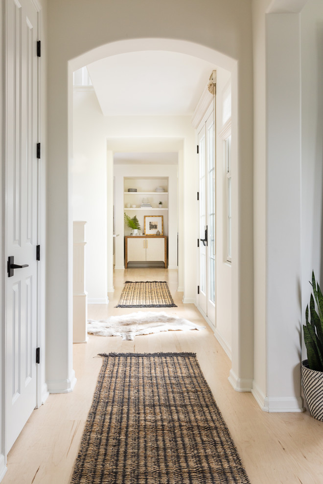 Cette image montre un couloir traditionnel avec un mur blanc, parquet clair et un sol beige.