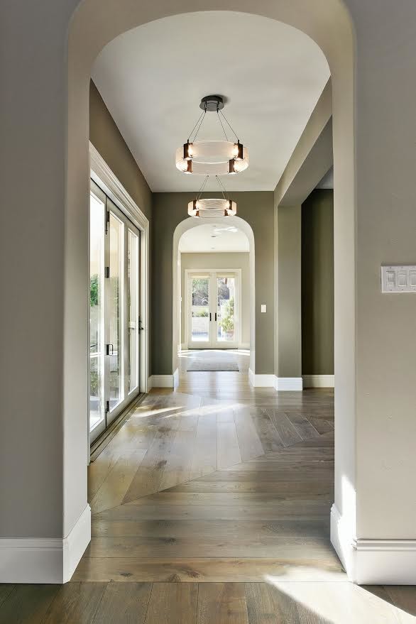 Пример оригинального дизайна: коридор среднего размера в стиле неоклассика (современная классика) с бежевыми стенами, светлым паркетным полом и коричневым полом