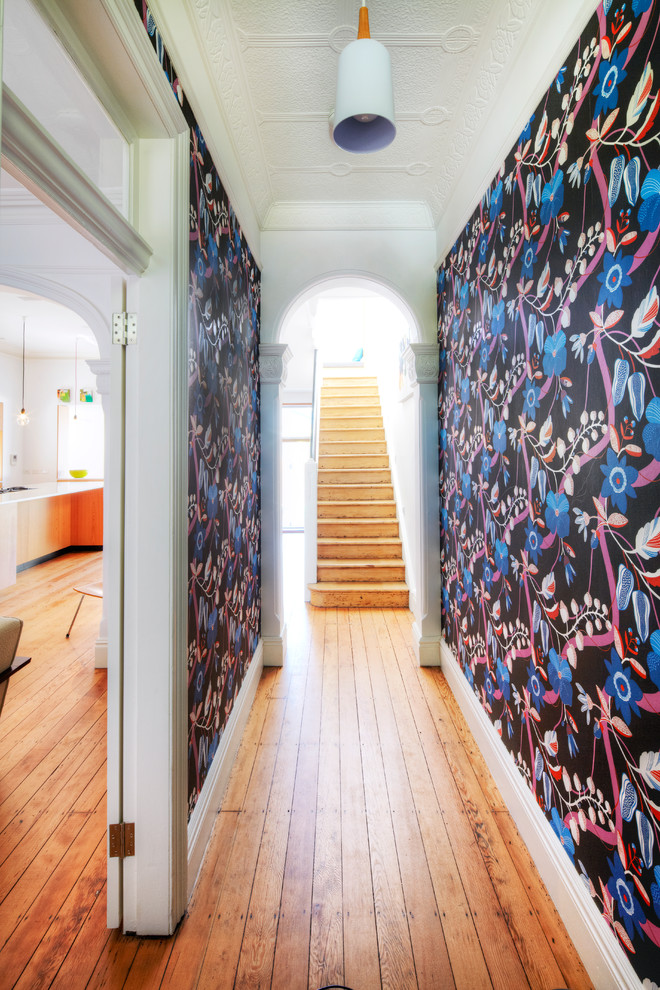 Idee per un ingresso o corridoio minimal di medie dimensioni con pareti multicolore e pavimento in legno massello medio