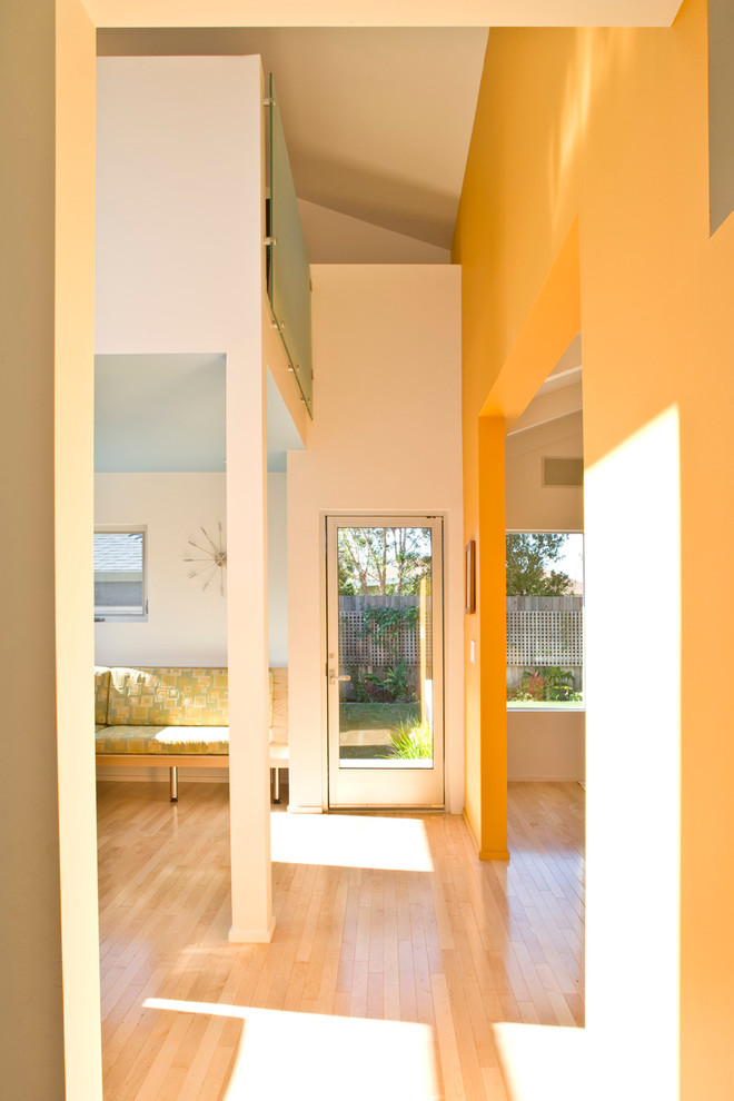 Foto de recibidores y pasillos contemporáneos con parades naranjas y suelo de madera clara