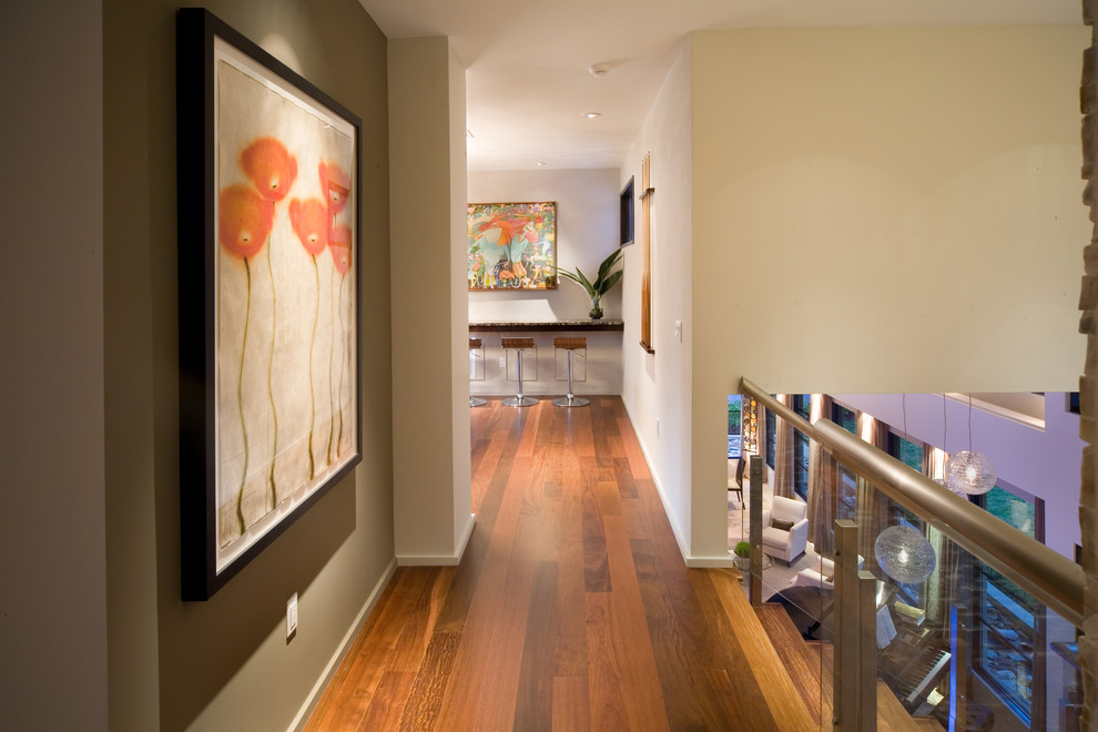 Hallway - contemporary medium tone wood floor hallway idea in Orlando with beige walls