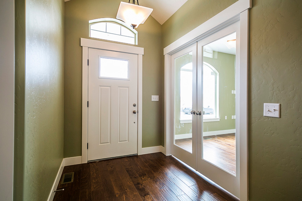 Inspiration pour un grand couloir craftsman avec un mur vert et un sol en bois brun.