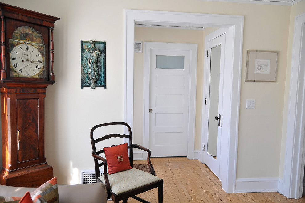 Inspiration for a small transitional light wood floor hallway remodel in Milwaukee with yellow walls