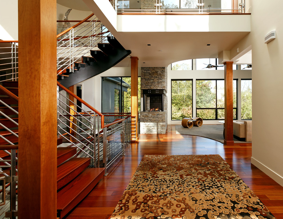Imagen de recibidores y pasillos actuales grandes con paredes blancas, suelo de madera en tonos medios y suelo marrón