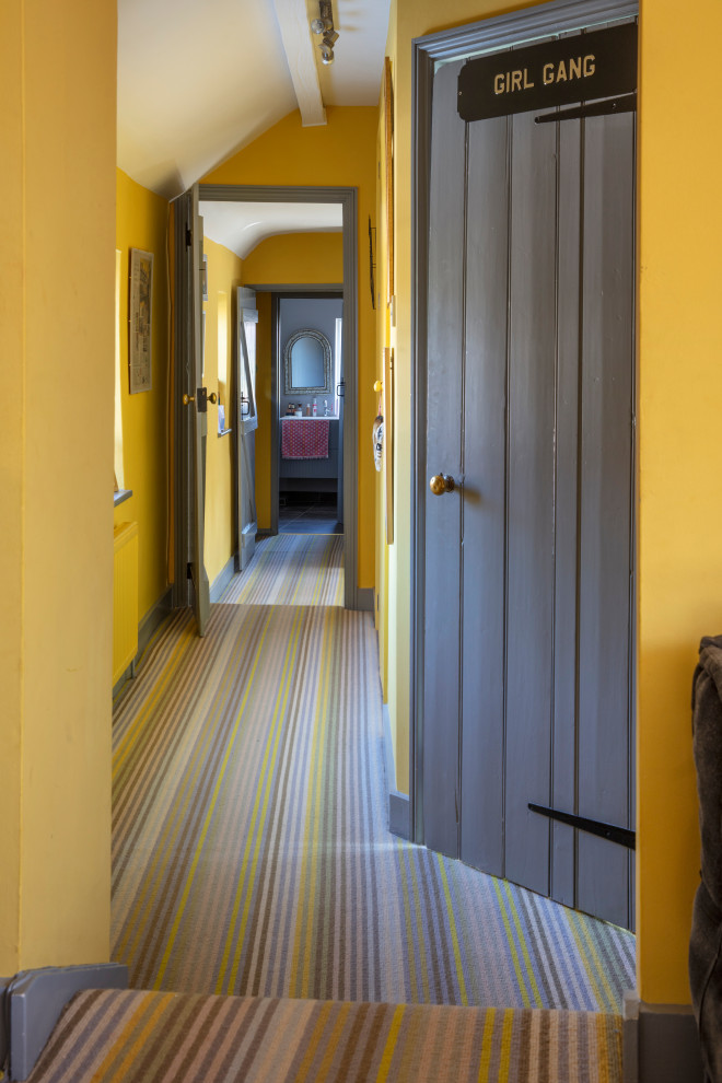 Idées déco pour un couloir éclectique avec un mur jaune, moquette et un sol jaune.