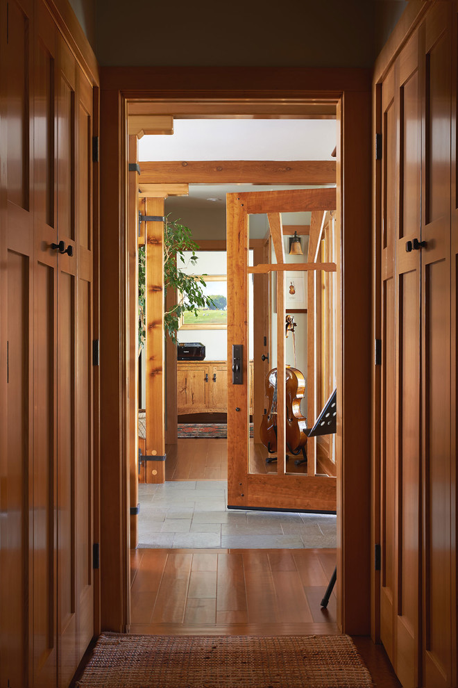 Idées déco pour un petit couloir craftsman avec un mur beige et un sol en bois brun.