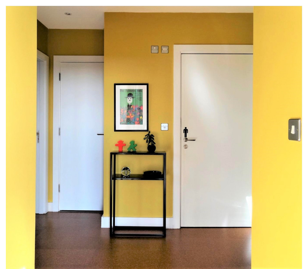 Foto på en mellanstor eklektisk hall, med gula väggar, korkgolv och brunt golv