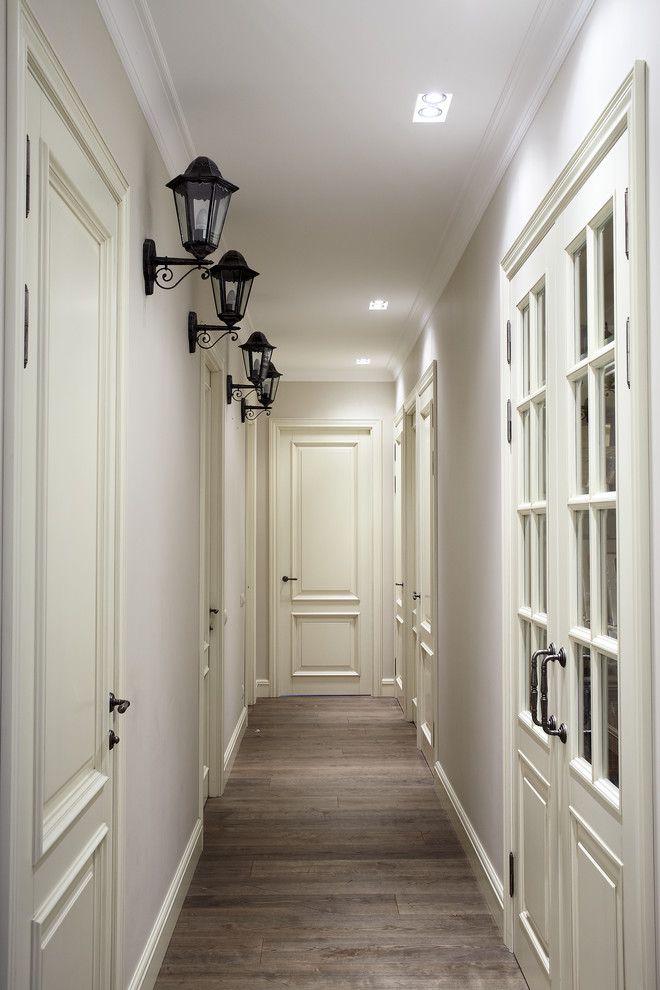 Свежая идея для дизайна: узкий коридор в классическом стиле с белыми стенами и паркетным полом среднего тона - отличное фото интерьера