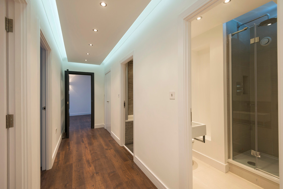 Small trendy medium tone wood floor hallway photo in London with white walls