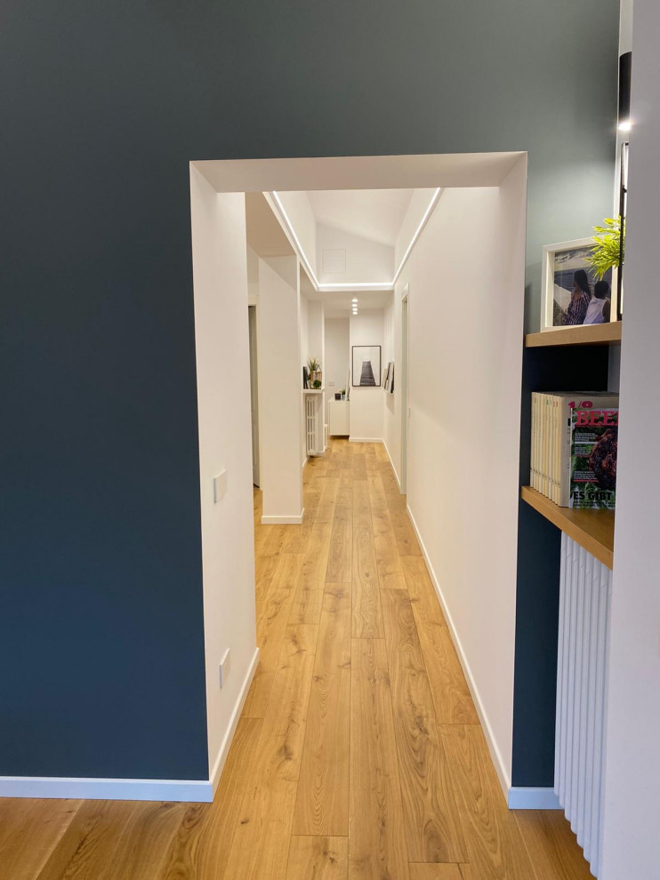 Esempio di un ingresso o corridoio minimalista di medie dimensioni con pareti bianche e pavimento in laminato