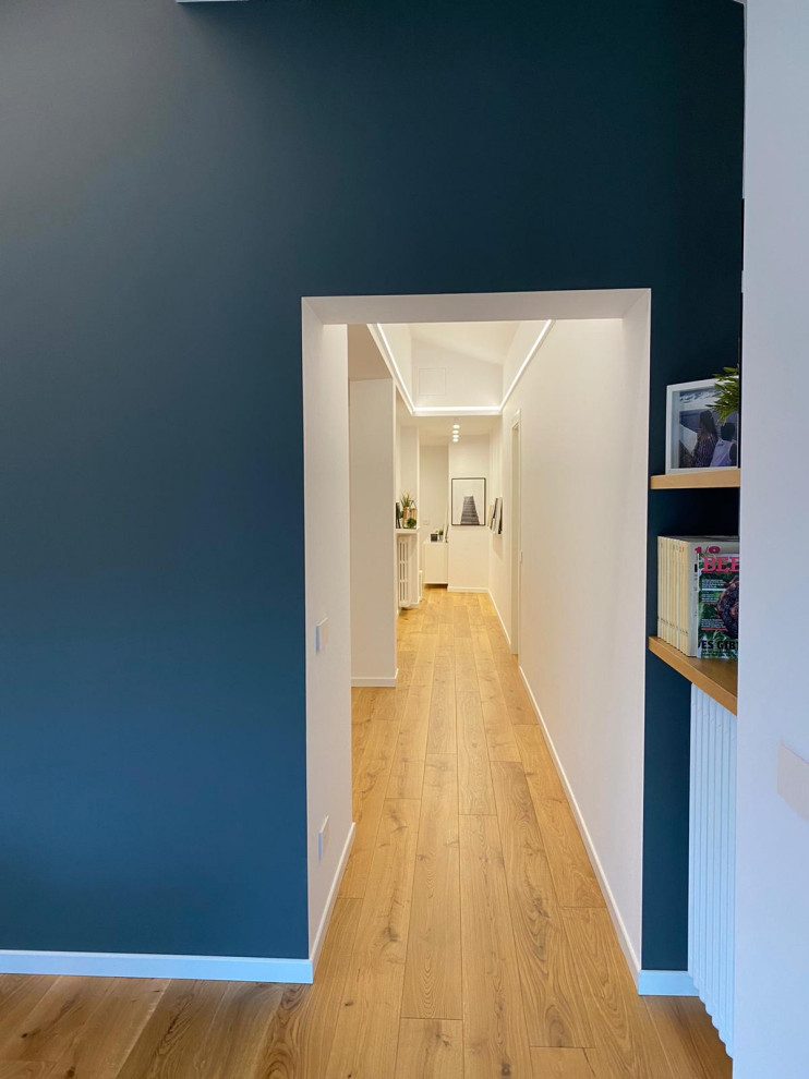 Imagen de recibidores y pasillos minimalistas de tamaño medio con paredes blancas y suelo laminado